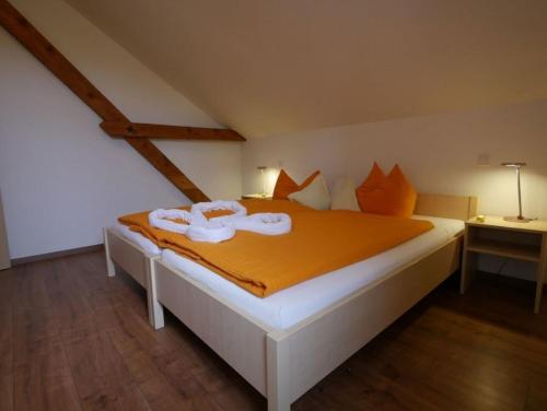 奥克森豪森Ferienwohnung 7的一间卧室配有一张带橙色床单的大床
