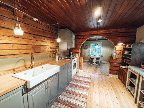 耶利瓦勒Taiga Forest Lodge的厨房设有木墙和白色水槽