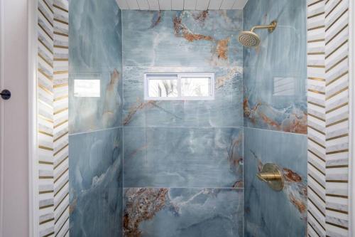 辛辛那提Newly Renovated House-10 Minutes From Downtown的浴室设有蓝色瓷砖淋浴和窗户。