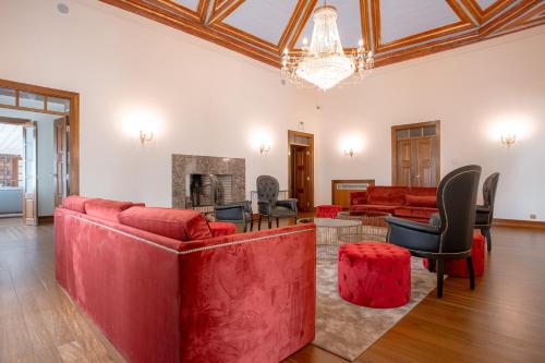 科英布拉Palacio São Silvestre-Boutique Hotel的客厅配有红色家具和壁炉