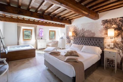 巴贝里诺·迪·穆杰罗Il Castelluccio Country Resort Restaurant & SPA的一间卧室设有一张大床和一个浴缸