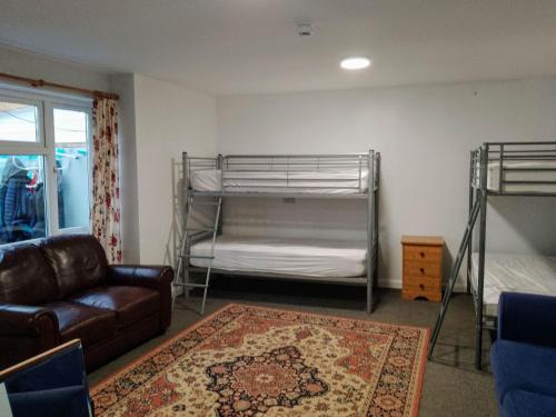廷塔杰尔Dolphins Backpackers的客厅配有两张双层床和一张沙发