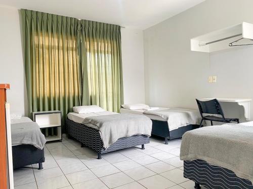 阿纳波利斯Hotel Central de Anápolis的一间医院房间,设有三张床和窗户