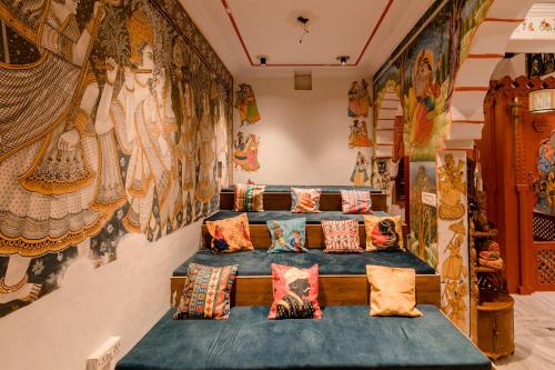 布什格尔Madpackers Pushkar的客房设有枕头和带绘画的墙壁。