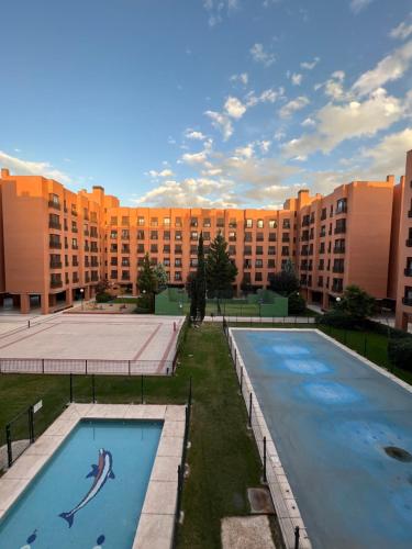 马德里Samaniego suite, AirPort, ifema turístico的一座大型建筑,前面设有两个游泳池