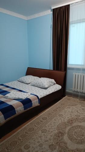 阿特劳Гостевой дом Самурук的一间卧室设有一张床和蓝色的墙壁