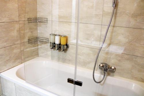维也纳Goldberger Apartment 1020的浴缸旁的玻璃门淋浴