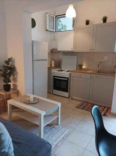 依克希亚Comfy Cozy Iksia的厨房配有桌子、冰箱和桌子