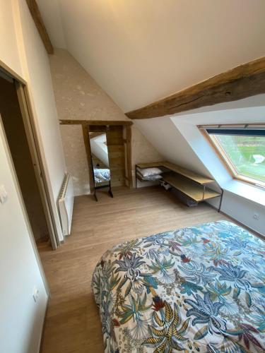 Lailly-en-ValGite des Colverts的阁楼卧室设有床和窗户。