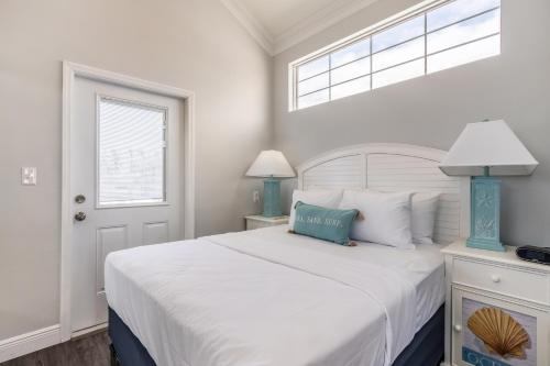 雷顿Fiesta Key RV Resort Waterfront Cottage 33的白色的卧室设有一张大床和一个窗户