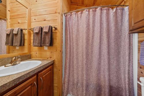克恩维尔Deluxe little cabin 2 min stroll to Kern River的浴室配有淋浴帘和盥洗盆。