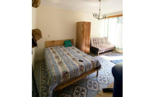 危地马拉Hermoso Loft en el Circulo的一间卧室配有一张床和一张沙发