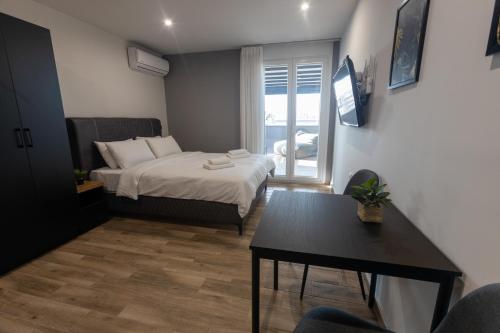 雅典Raise Athens Metro Apartments的小房间设有一张床和一张桌子