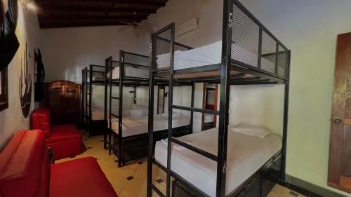格拉纳达Encuentros的带4张双层床和红色沙发的客房