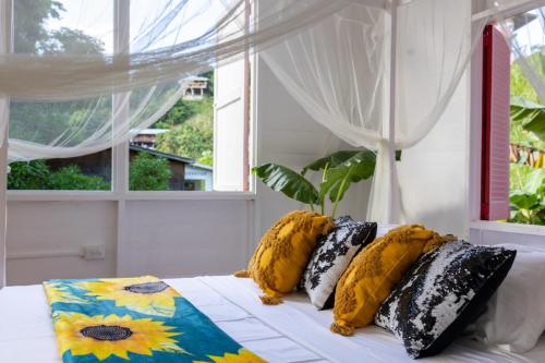 CastaraCastara Cottage by Hello Mello的卧室配有带枕头的床铺和窗户。