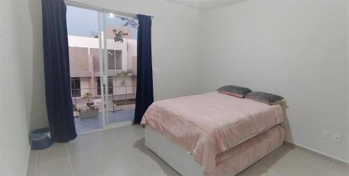 普拉亚卡门La Ceiba的一间卧室设有一张床和一个大窗户