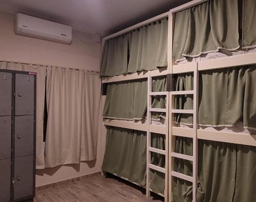 圣拉斐尔Privilegio Hostel的配有双层床和窗帘的房间