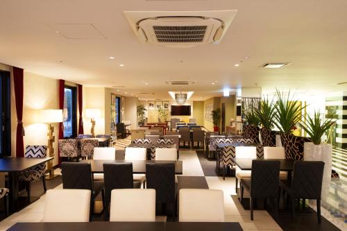 神户神户站百夫长大酒店的一间设有白色椅子和桌子的餐厅