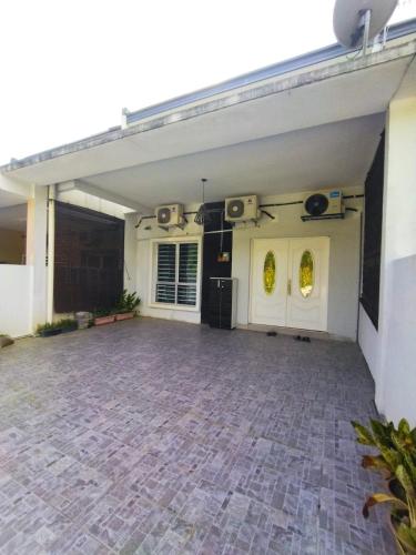 雪邦D'Indah59 KLIA Homestay的一个带砖地板和白色门的车库