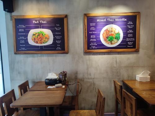 马尼拉Sea Residences MOA Complex - Ruffa's Condotel的餐厅的墙上有两张标牌,上面有桌子