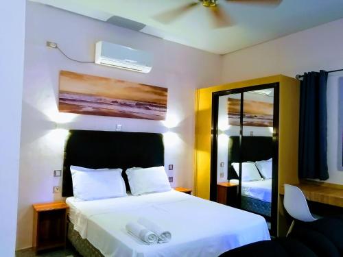 班塔延岛Marino Bungalows的卧室配有白色的床和镜子