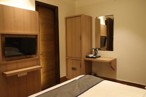 阿姆利则Hotel Crown Savoy, Near Railway Station & GURU NANAK DEV UNIVERSITY的酒店客房,配有床和镜子