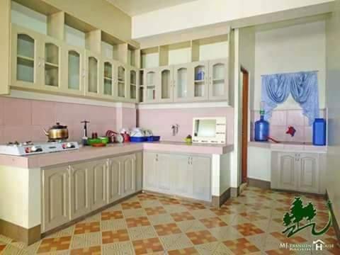碧瑶Mj Transient Homes的厨房配有白色橱柜和瓷砖地板。