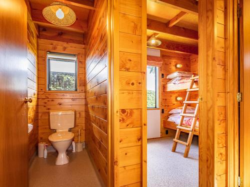 国家公园Rakau - National Park Holiday Home的小木屋浴室设有卫生间和双层床。