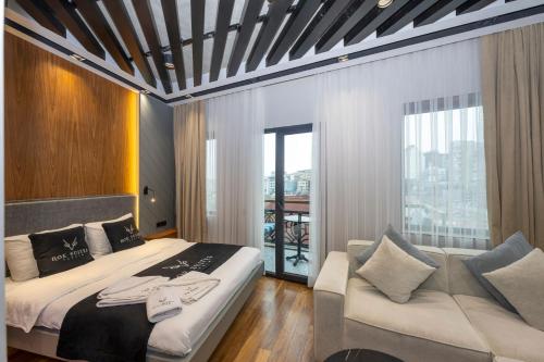伊斯坦布尔Roe Suite Hotel - TAKSIM的一间卧室配有一张大床和一张沙发