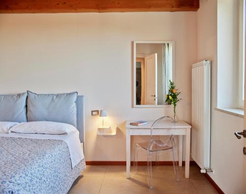 乌尔比诺Country House Ca'Balsomino的一间卧室配有一张床、一张桌子和一面镜子