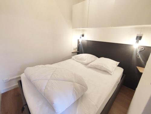 巴涅尔-德吕雄Le cerf charmant, T2, Luchon, wifi, balcon, 4 personnes的卧室配有白色的床和2个枕头