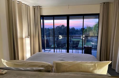 Ban Huai Thawai我爱大象度假村的一间卧室设有一张床和一个大型玻璃窗