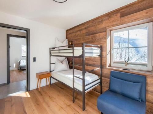 霍赫克尼希山麓丁滕Leni`s Mountain Appartements的一间卧室配有双层床和蓝色椅子