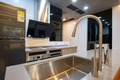 恒春古城垦丁馥境包栋Villa 的厨房配有不锈钢水槽和电视。
