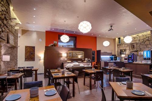 圣马力诺La Grotta Hotel的一间带木桌椅的餐厅和一间厨房