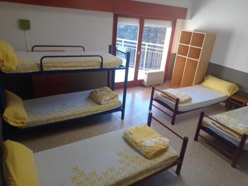 普拉诺拉斯Planoles Xanascat的客房设有三张双层床和一个阳台。