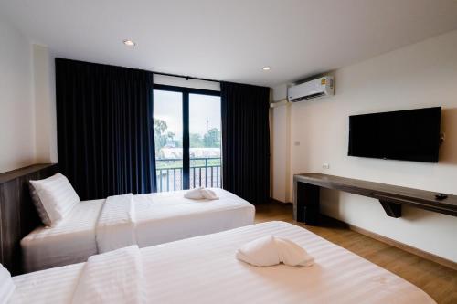 合艾JS HOTEL的酒店客房设有两张床和一台平面电视。