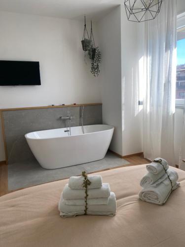 桑格罗堡Atmosphera home的带浴缸和床上毛巾的浴室