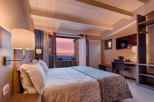 圣马力诺La Grotta Hotel的一间卧室设有一张床,享有海景