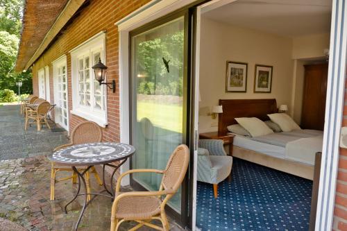 汉堡梅林伯格舒罗斯小房子酒店的一间卧室配有一张床,庭院设有一张桌子