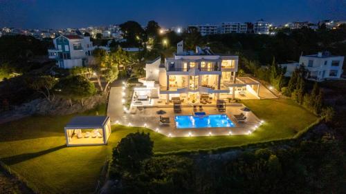 罗德镇Monte Smith Luxury Villa的享有房子空中景色,晚上有游泳池