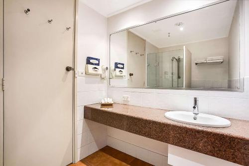 波特兰Richmond Henty Hotel的一间带水槽和镜子的浴室