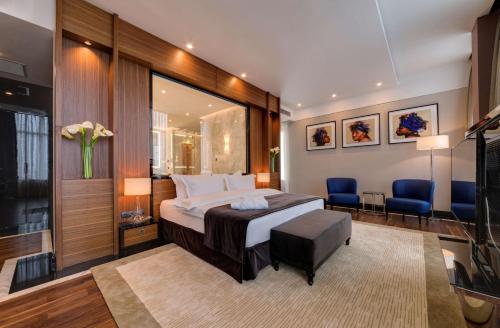 基希讷乌罗格朗丽笙酒店的一间卧室配有一张床和两张蓝色椅子