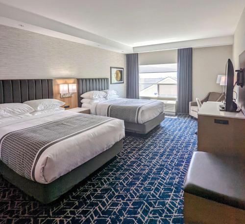 弗农Best Western Premier Route 97 Vernon的酒店客房设有两张床和电视。