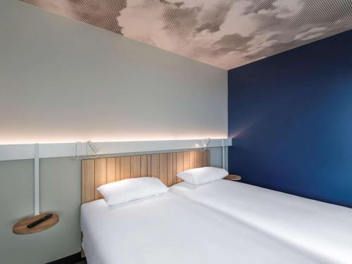 梅济约ibis Lyon Est Meyzieu的一间卧室设有一张蓝色墙壁的大床