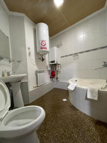 布哈拉Hotel Al Mansur的浴室配有卫生间、盥洗盆和浴缸。
