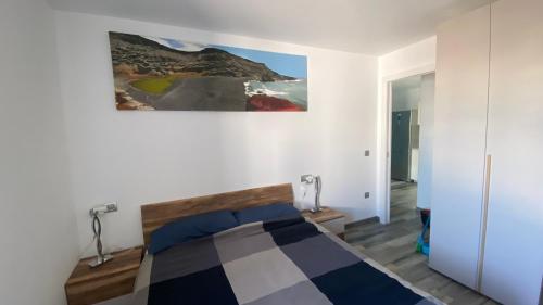 普拉亚布兰卡Casa salzano的卧室配有一张床,墙上挂有绘画作品