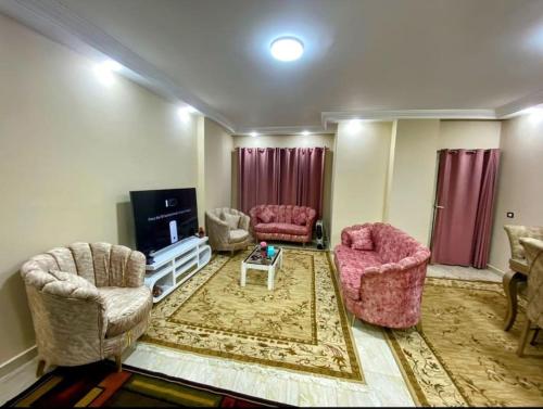 开罗Dreams House in Maadi的客厅配有两把椅子和电视