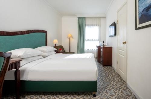 耶路撒冷Jerusalem Gold Hotel的一间卧室配有一张白色大床和绿色床头板