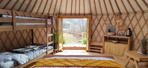 弗瑞兰Yourte des Verts Bois的蒙古包内一间卧室,配有两张双层床